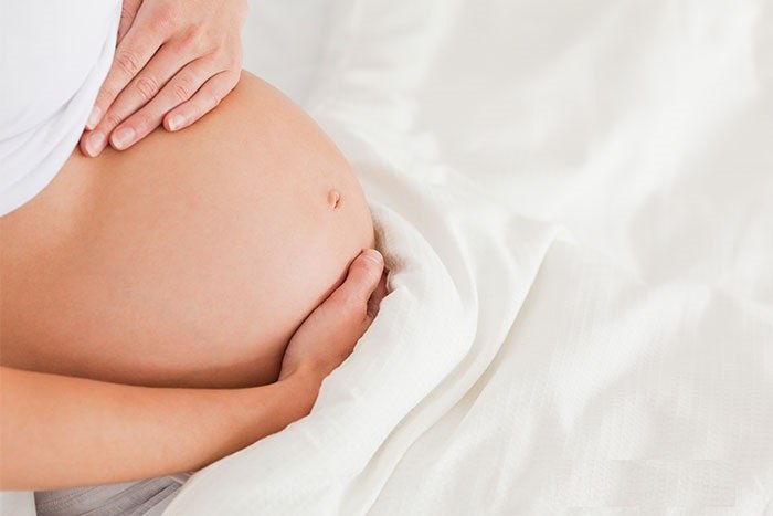 обнаженный живот беременной женщины